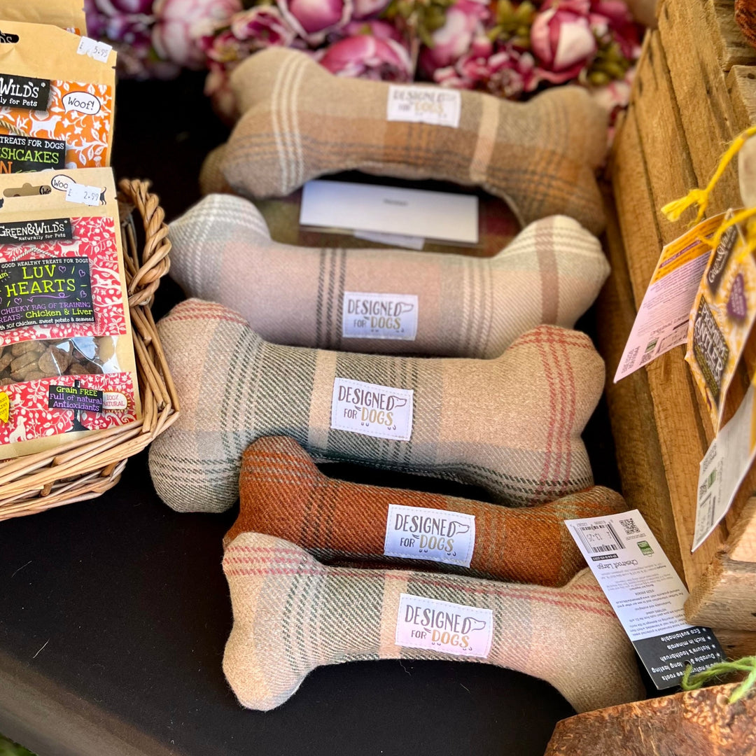 A collection of tweed patterned bone-shaped dog toys in different sizes.