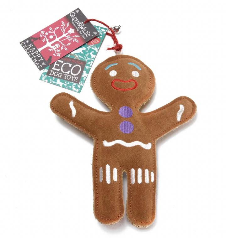 A brown plush gingerbread person dog toy with embroidered facial features and white icing details, shown with two branded hang tags reading Green and Wild's Dog Toys on a white background.
