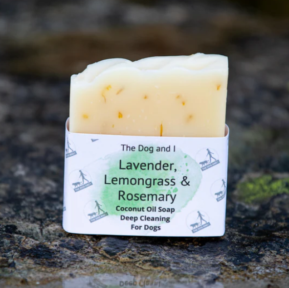 Bar of 'lavender, lemongrass and rosemary' dog soap with white packaging on a natural background 