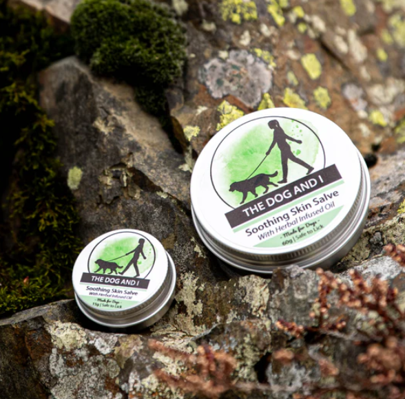 The 'Dog and I' skin salve with herbal infused oil, 15g tin. With a green label showing a person walking a dog.