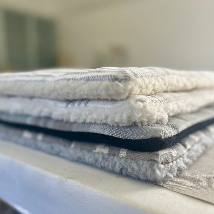 Stack of extra small mats in various fabrics. 