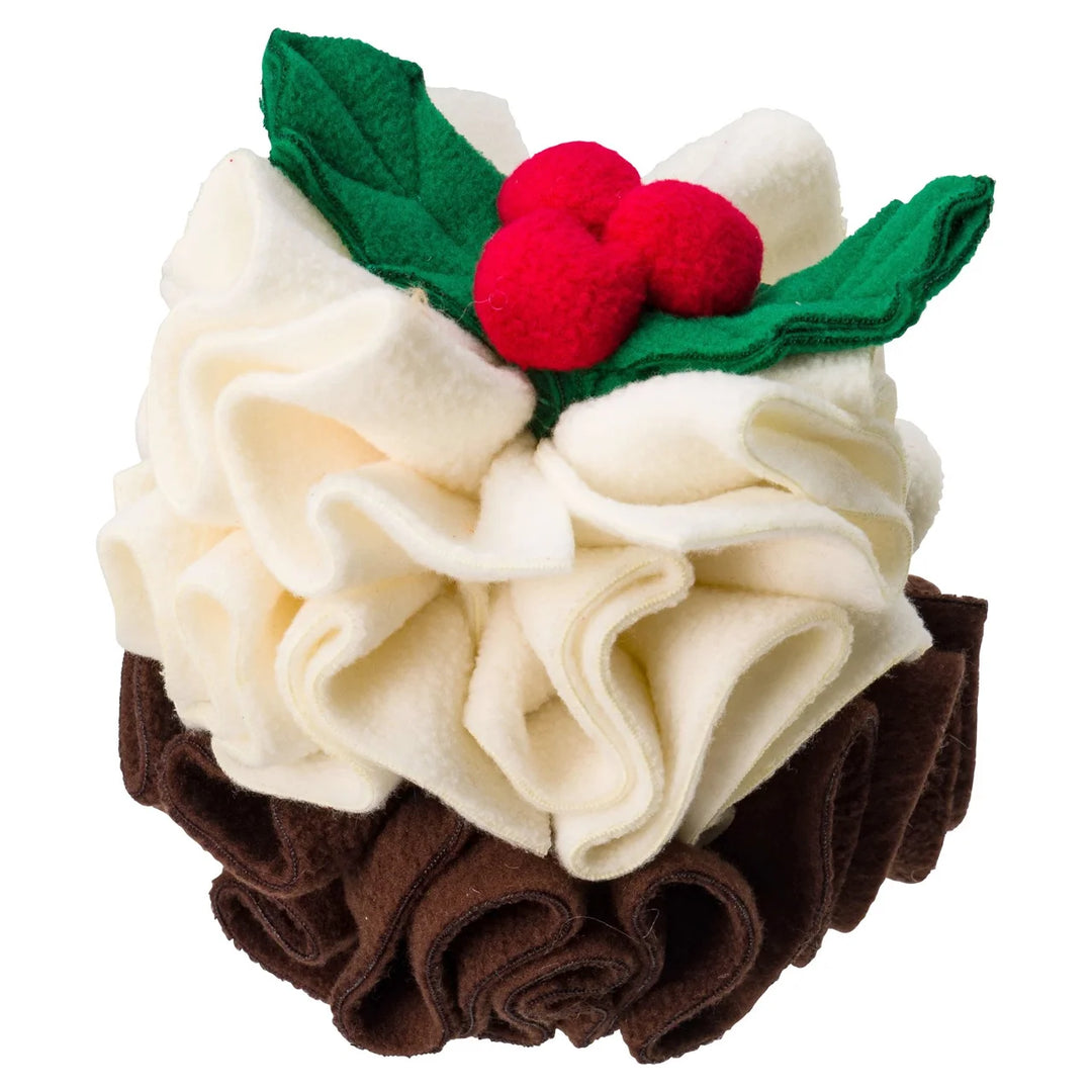 A plush Christmas pudding toy made from felt, featuring cream-colored whipped cream, a dark brown ruffled base, green leaves, and three red berries on a white background.
