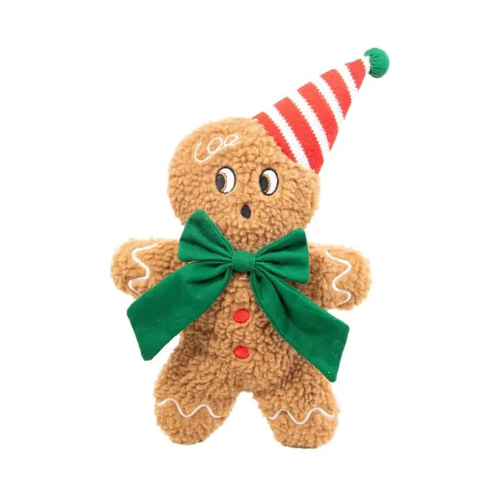 A plush gingerbread person toy with a brown textured body, white icing details, a green bow, red buttons, and a red-and-white striped party hat, shown on a plain white background.